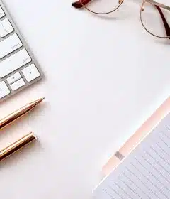 pen near black lined paper and eyeglasses